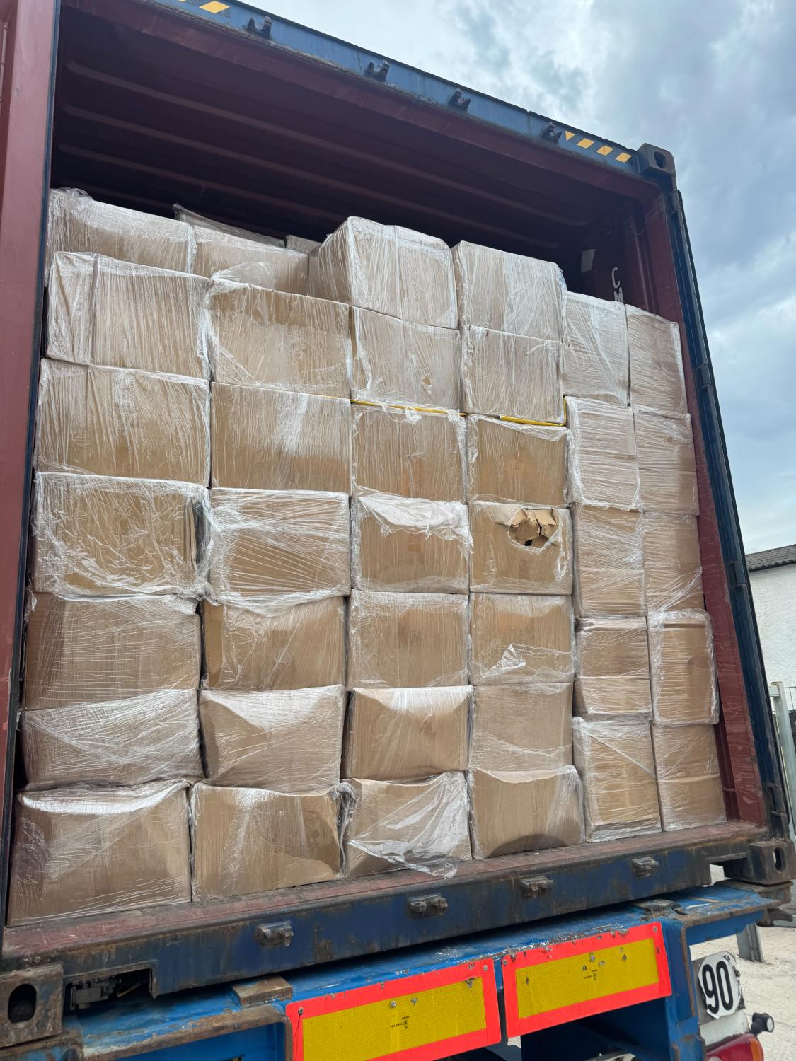Container d'expédition chargé de palettes filmées, prêt au départ